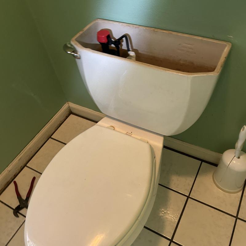 Toilet tank with rebuilt bowl gasket in bathroom