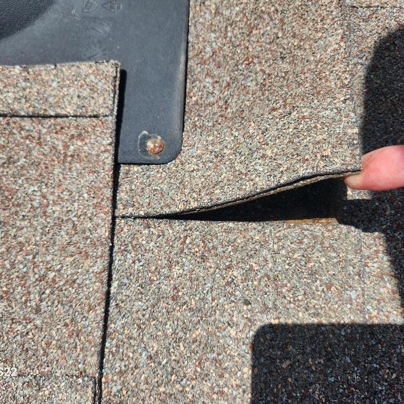Roof shingles lifting near pipe flashing inspection