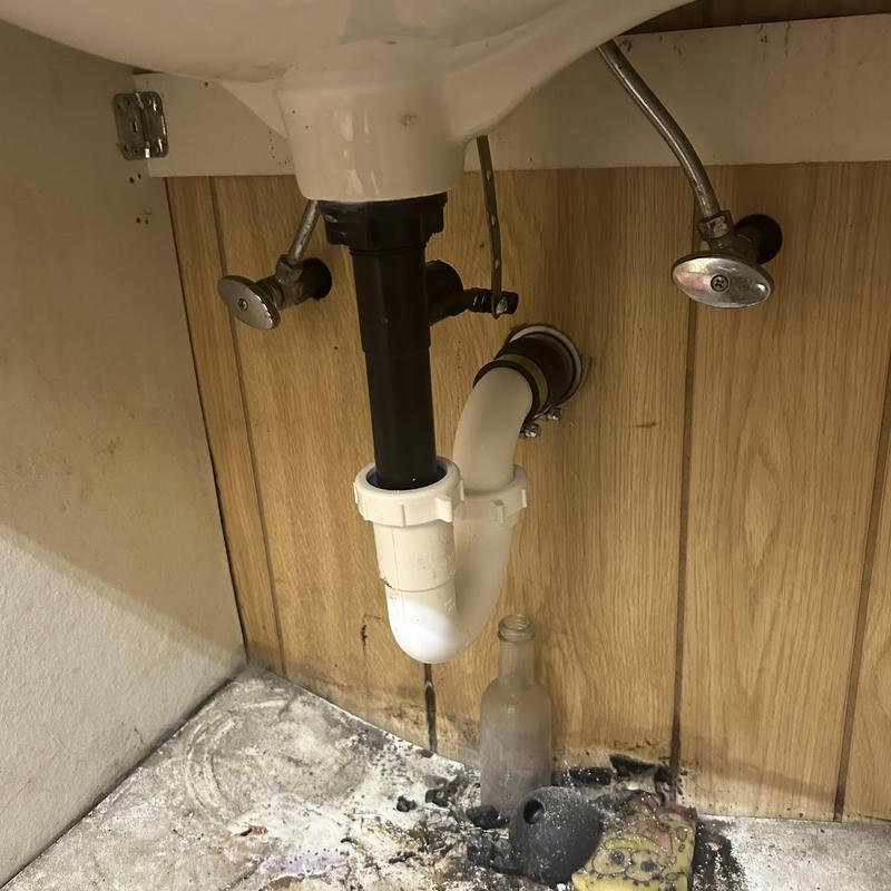 P-trap and drain pipe under sink with debris