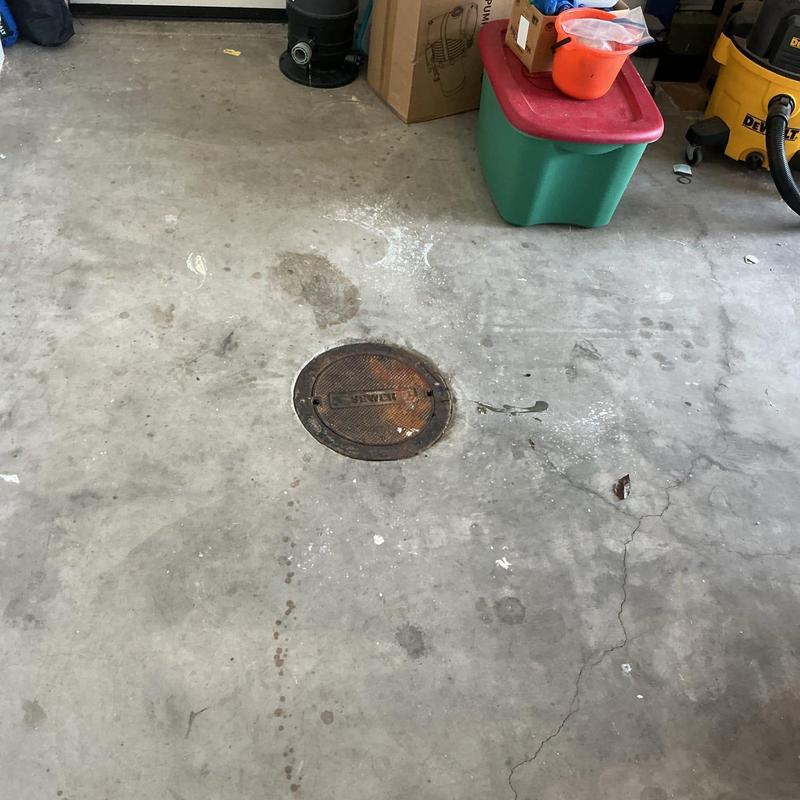 Main sewer line cleanout cover on concrete floor