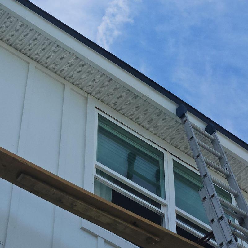 Soffit panels with ladder and scaffolding near windows Soffit panels with ladder and scaffolding near windows