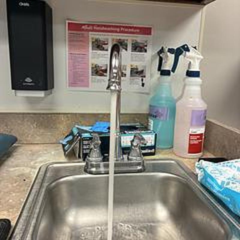 Faucet spout and handles with running water in classroom