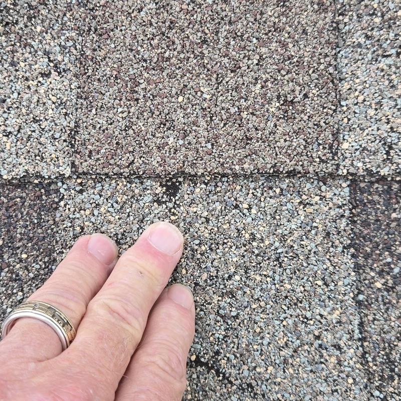 Roof shingles with visible gaps indicating leaks