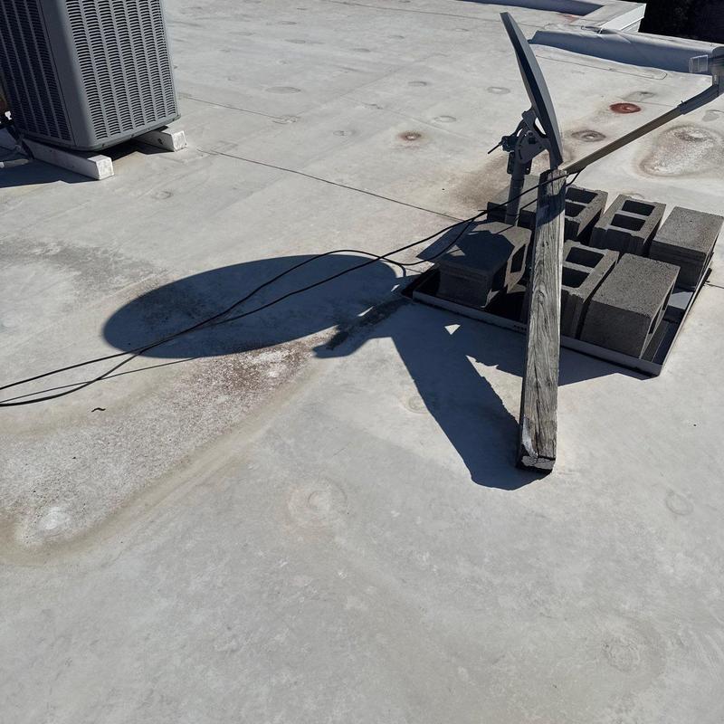 Commercial flat roof with hail damage and debris blocks