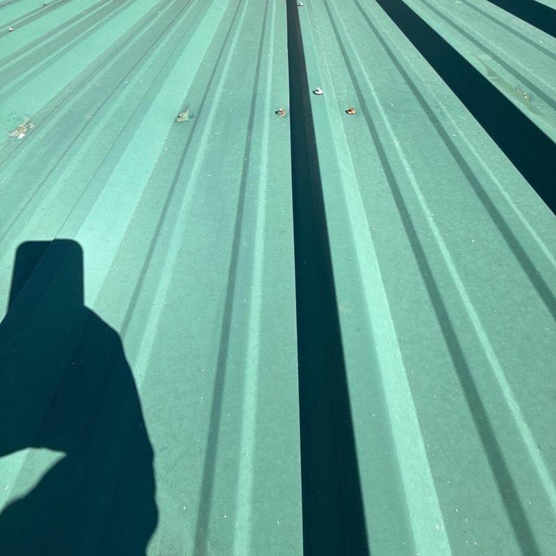 Metal roofing panels with hail damage and fasteners