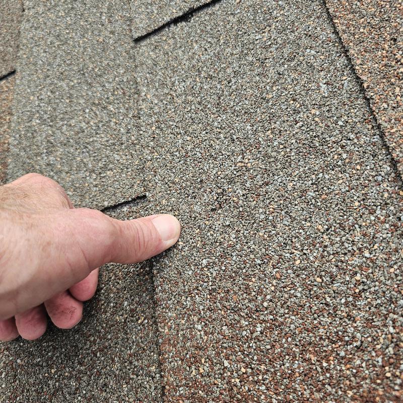 Asphalt roof shingles with hail damage close-up