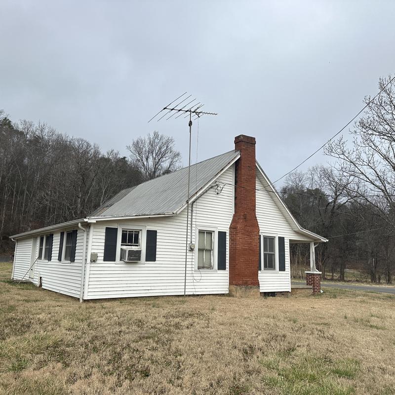Metal roof on white house with brick chimney