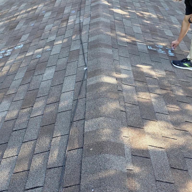 Asphalt shingle roof with hail damage marks and inspection