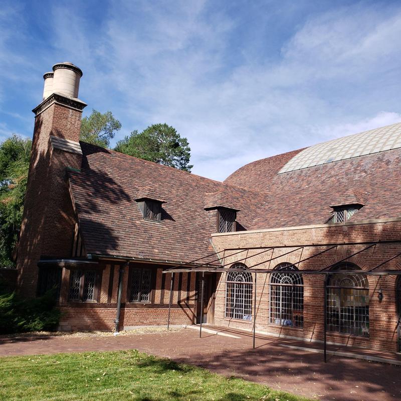Brick chimney and shingled roof under clear sky