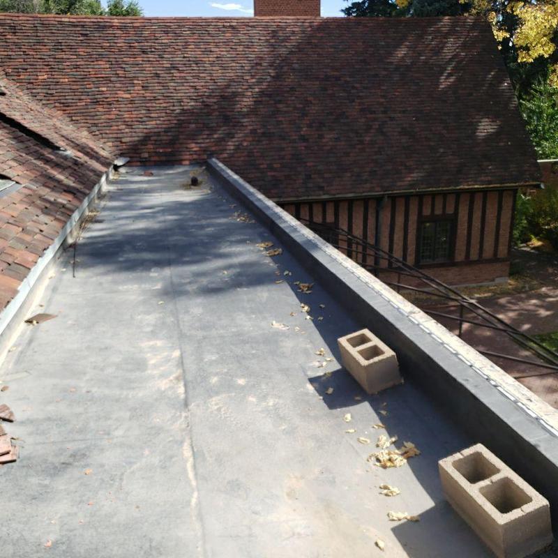 Flat roof with leaks around roof drains and debris