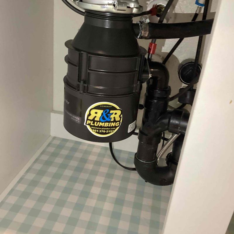 Garbage disposal unit with plumbing connections under sink