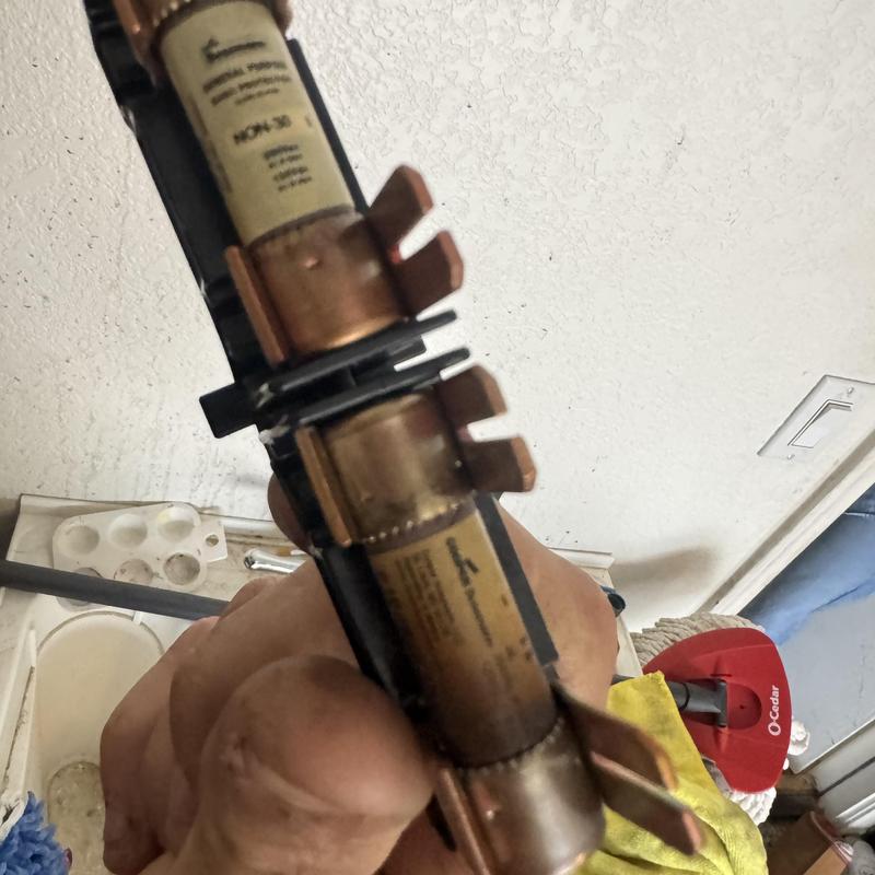 Water heater fuse held in hand near electrical box