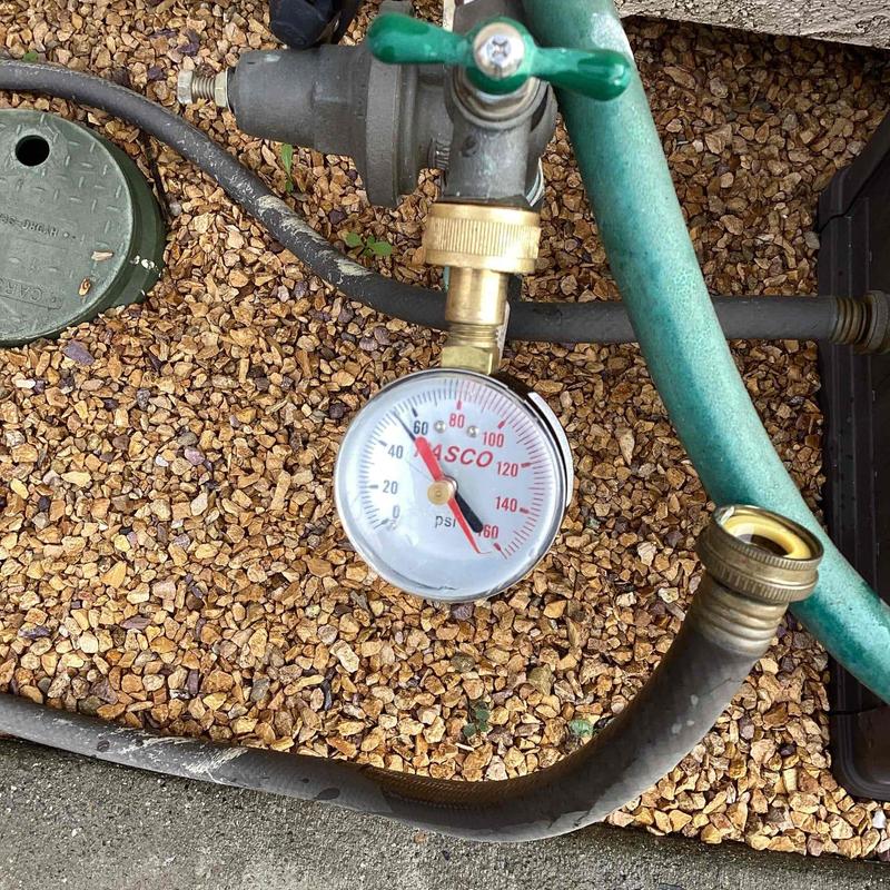 Water pressure gauge attached to garden hose valve