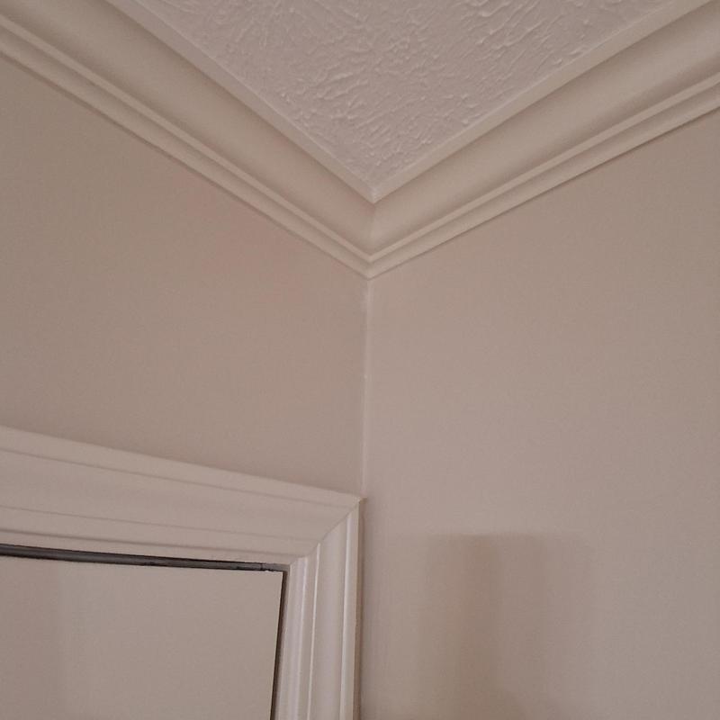 Wall corner trim and crown molding installation close-up Wall corner trim and crown molding installation close-up
