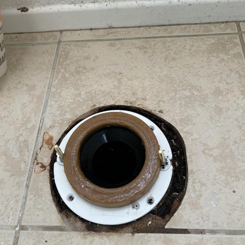 Toilet closet flange with new wax ring on tile floor