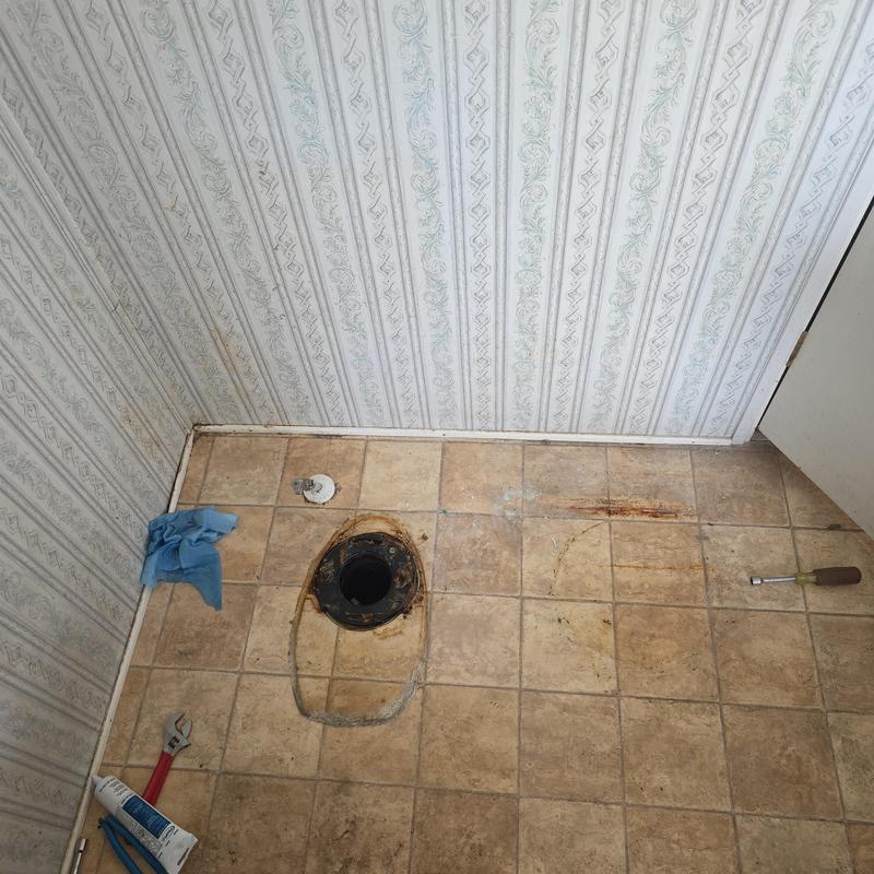 Toilet flange and floor tile with removed toilet installation tools