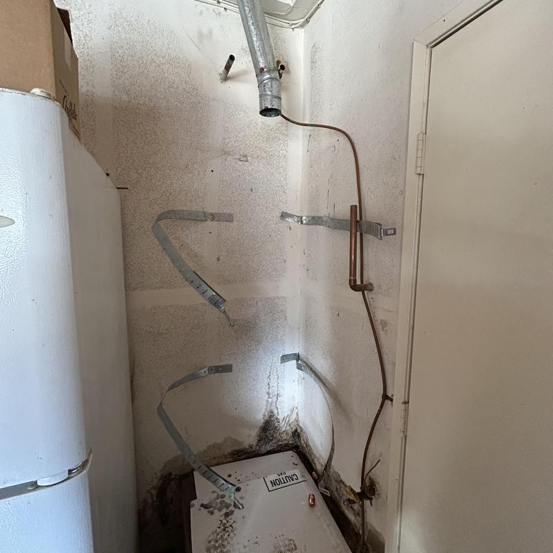 Water heater removal area with mounting brackets and gas line