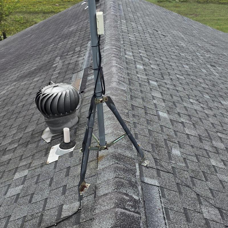 Asphalt roof shingles with hail damage near vent pipe