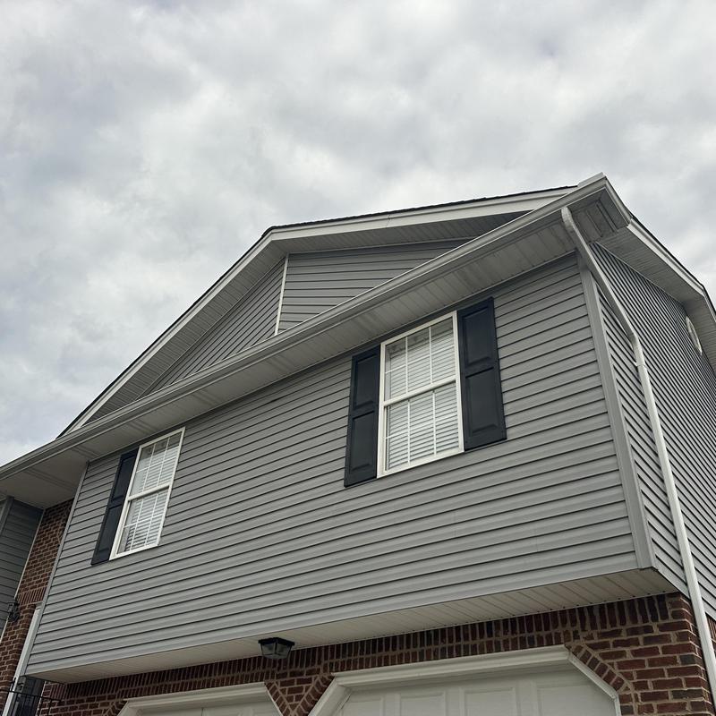 Shingle roof on residential gray siding house