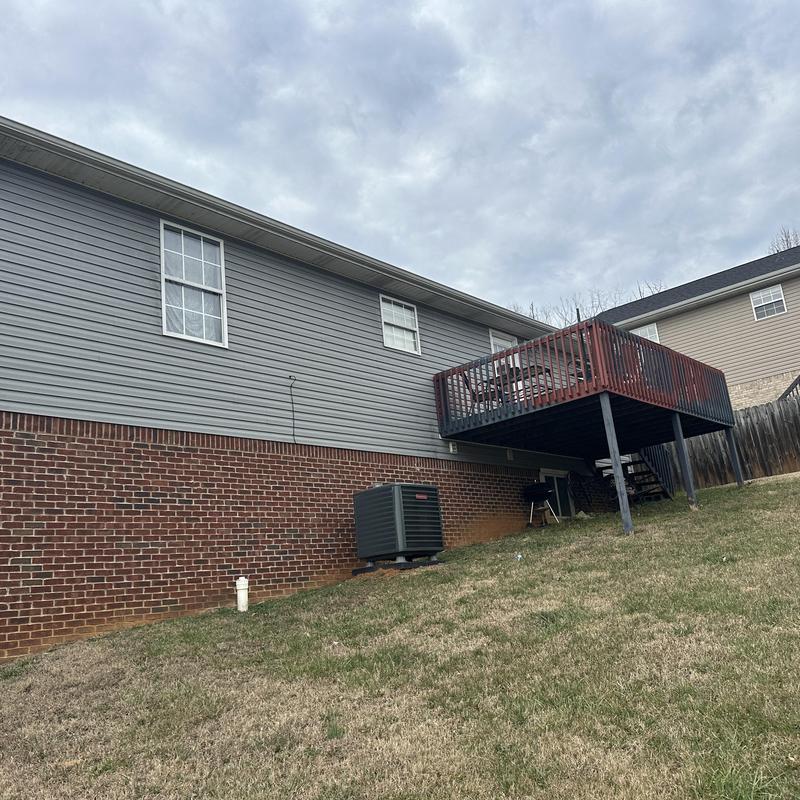 Heat pump unit outside residential brick and siding home