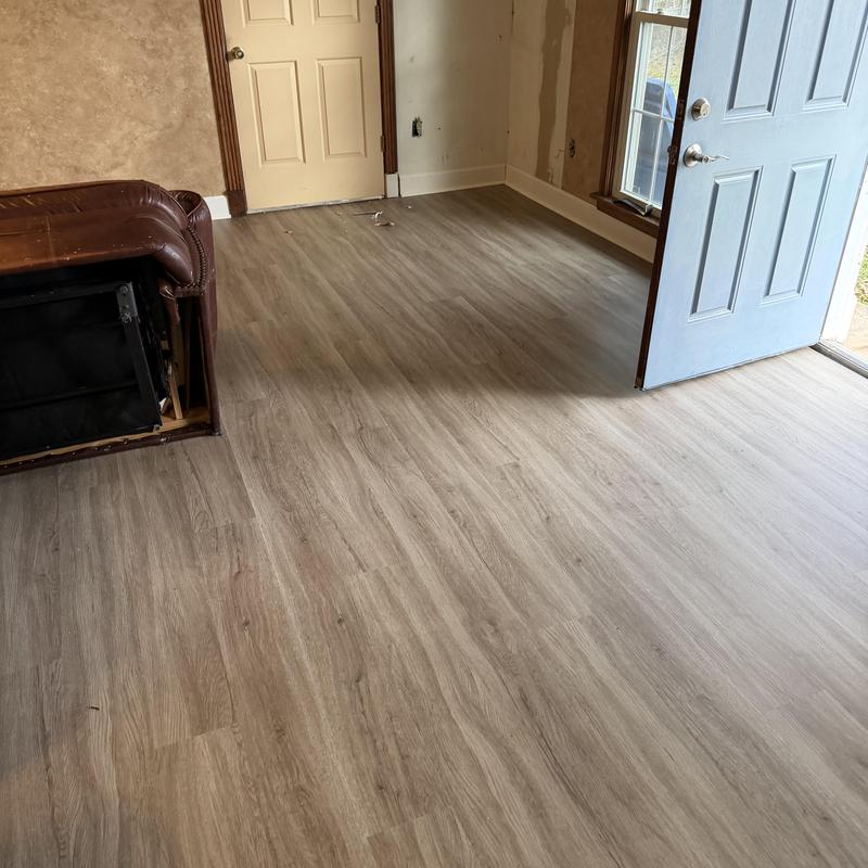 Vinyl plank floor with baseboard and quarter round installed Vinyl plank floor with baseboard and quarter round installed