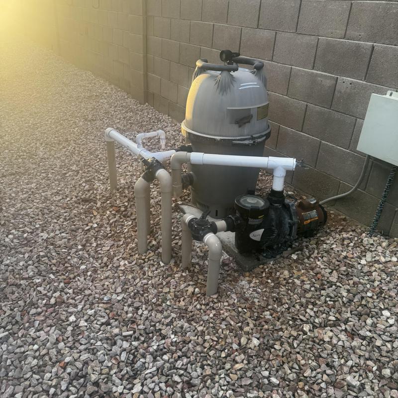 Pool filter and pump with PVC piping in backyard