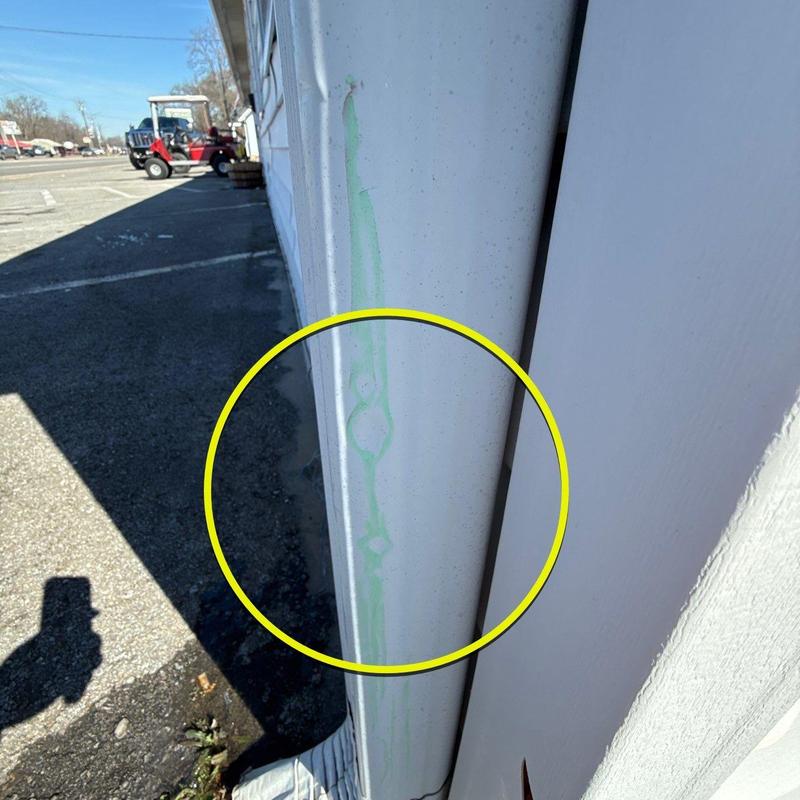 Metal downspout with hail damage marked in green