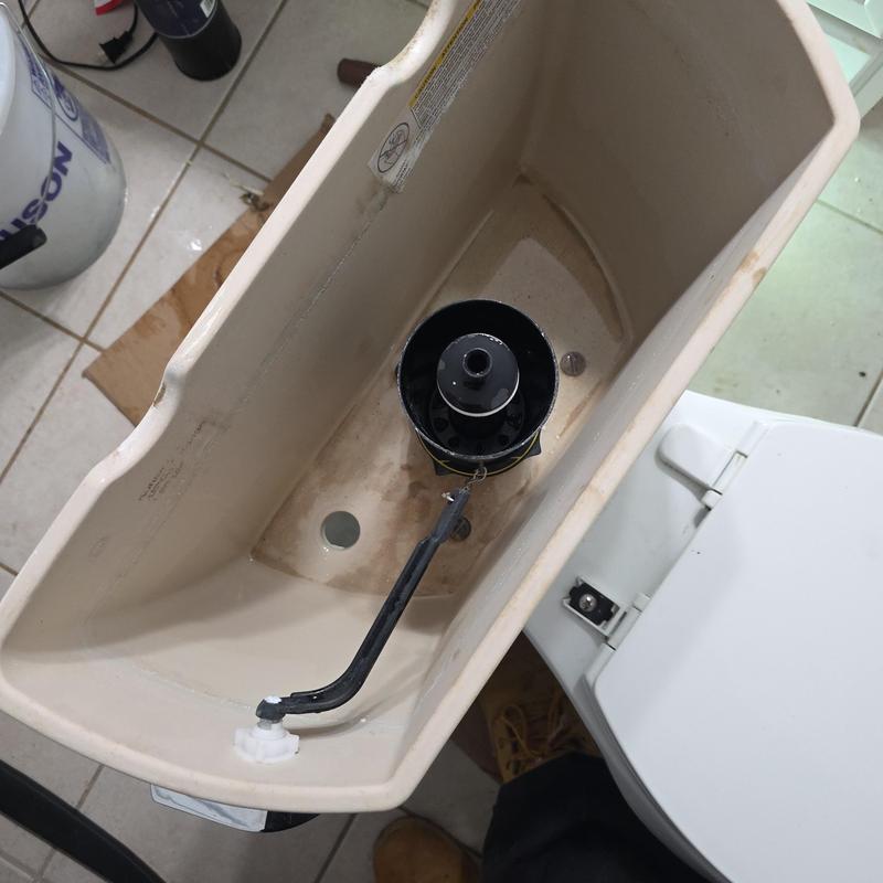 Toilet fill valve inside tank with plumbing tools nearby