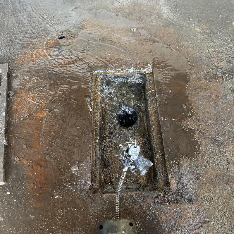 Drain grate and sewer machine cable clearing blockage