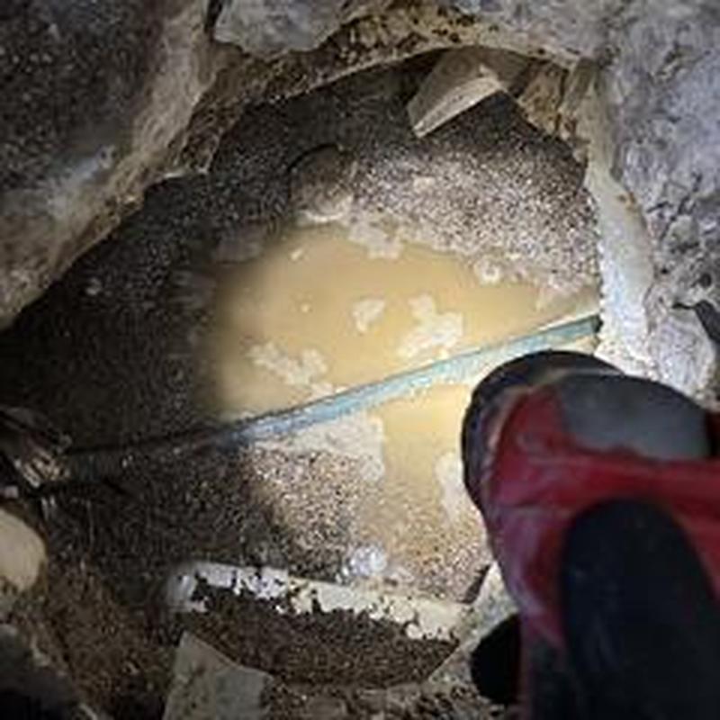 Broken underground water pipe excavation with flashlight
