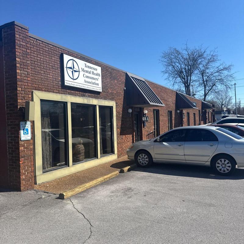 Brick exterior wall and office windows with parked cars