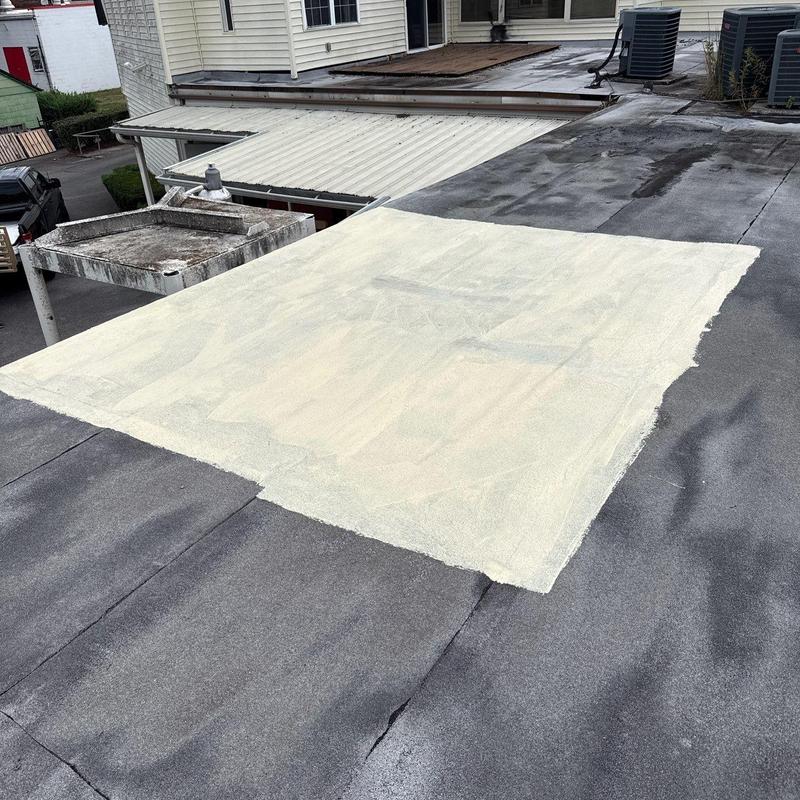 Flat roof coating patch on built-up roof surface