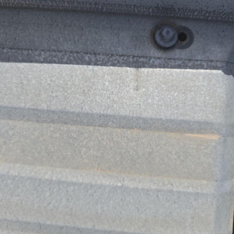 Metal roof panel close-up with fastening screw