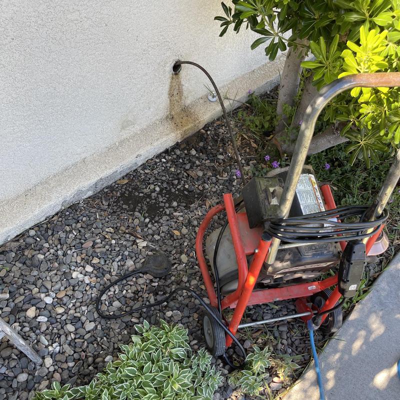 Drain snake clearing exterior pipe from kitchen sink stoppage