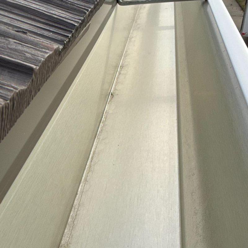 Seamless aluminum gutter installation in silver gray