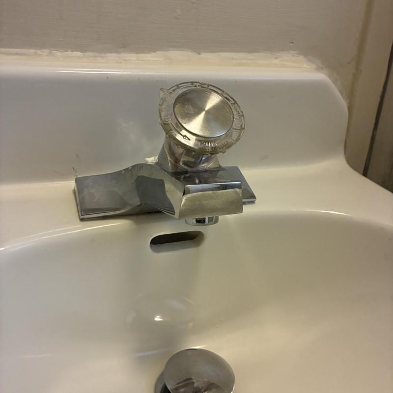 Basin faucet with single handle on white sink
