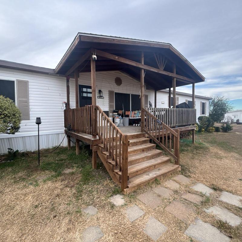 Wooden front porch with stairs and railing outdoors