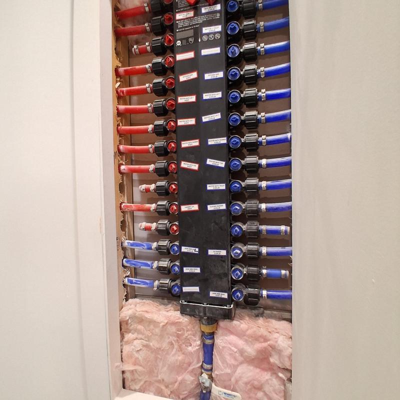 Plumbing manifold with red and blue PEX piping installed Plumbing manifold with red and blue PEX piping installed