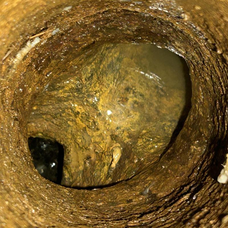 Cast-iron sewer pipe interior with blockage buildup