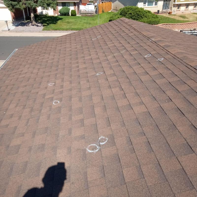 Asphalt shingle roof with marked hail damage spots