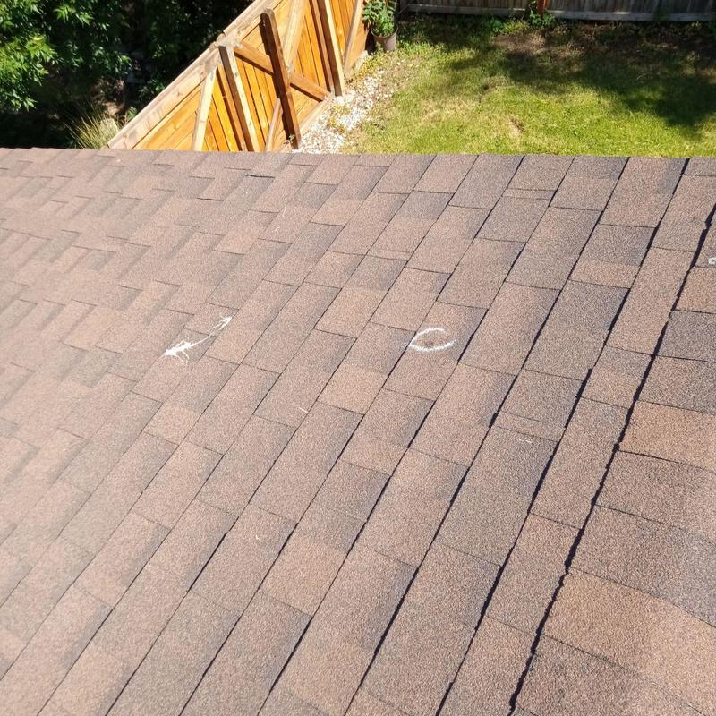 Asphalt shingle roof with hail damage marked for replacement