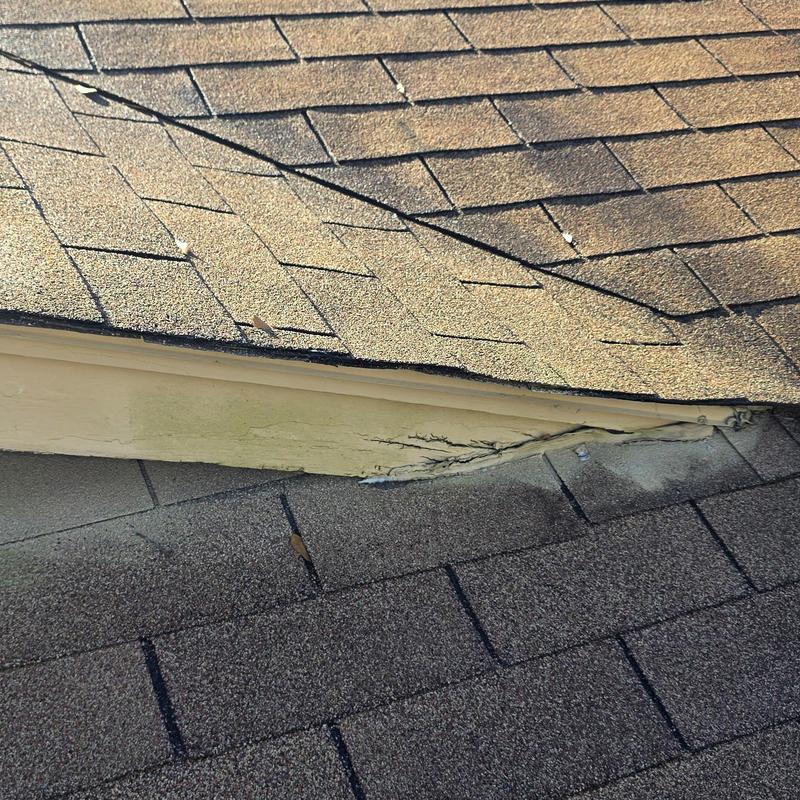 Asphalt shingle roof with damaged flashing and trim