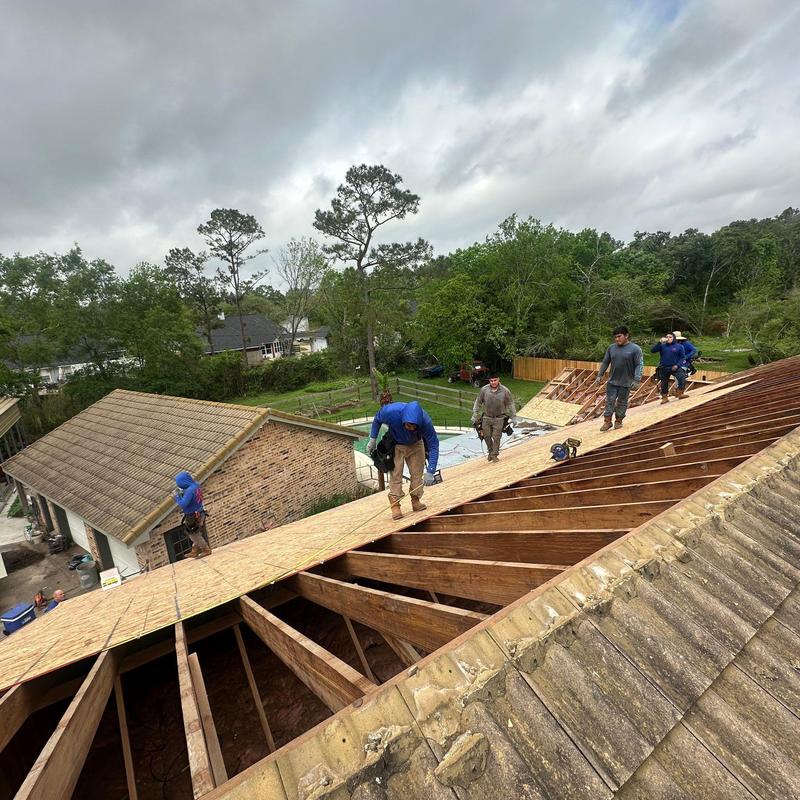 Roof decking installation with workers on wooden frame Roof decking installation with workers on wooden frame
