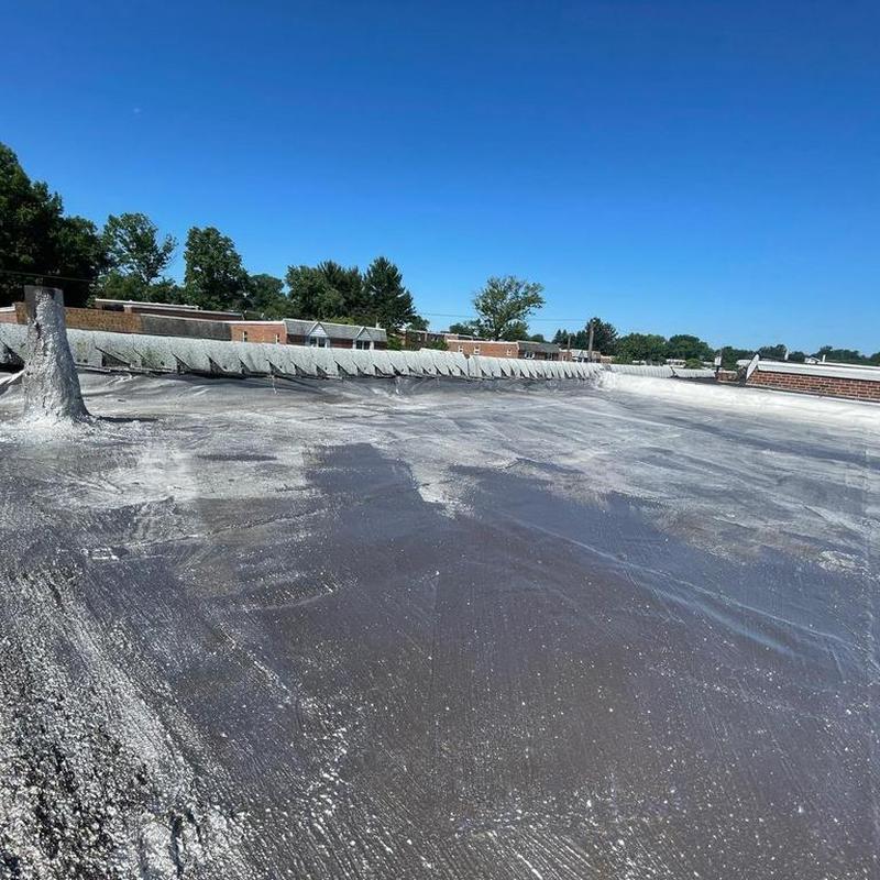 Flat roof with roof cement and silver coating application