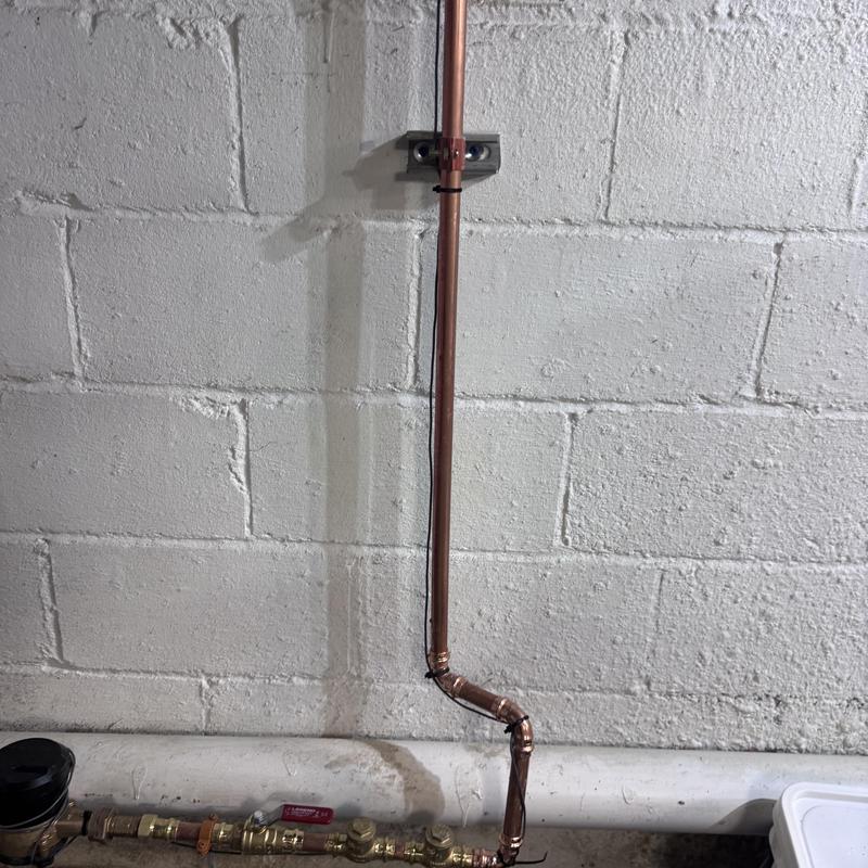Water meter and copper line installation on basement wall