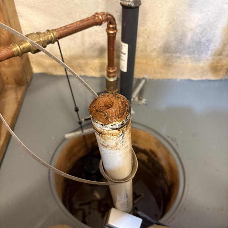 Sump pump discharge pipe clogged with compacted red clay