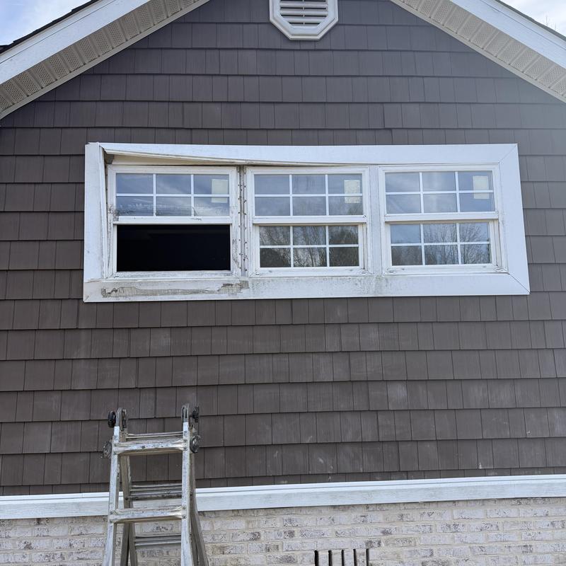 Old broken window removal on brown shingle house Old broken window removal on brown shingle house