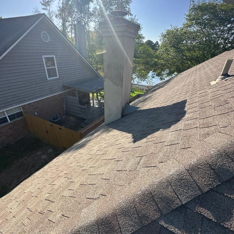 Roof shingles and chimney inspection with sunlight glare