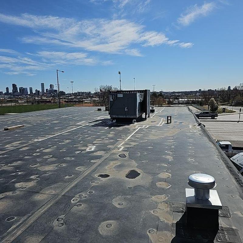 EPDM flat roof with worn seam repairs and equipment EPDM flat roof with worn seam repairs and equipment