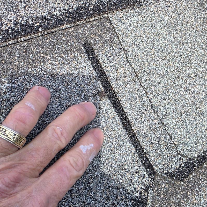 Asphalt roof shingles with hail damage close-up